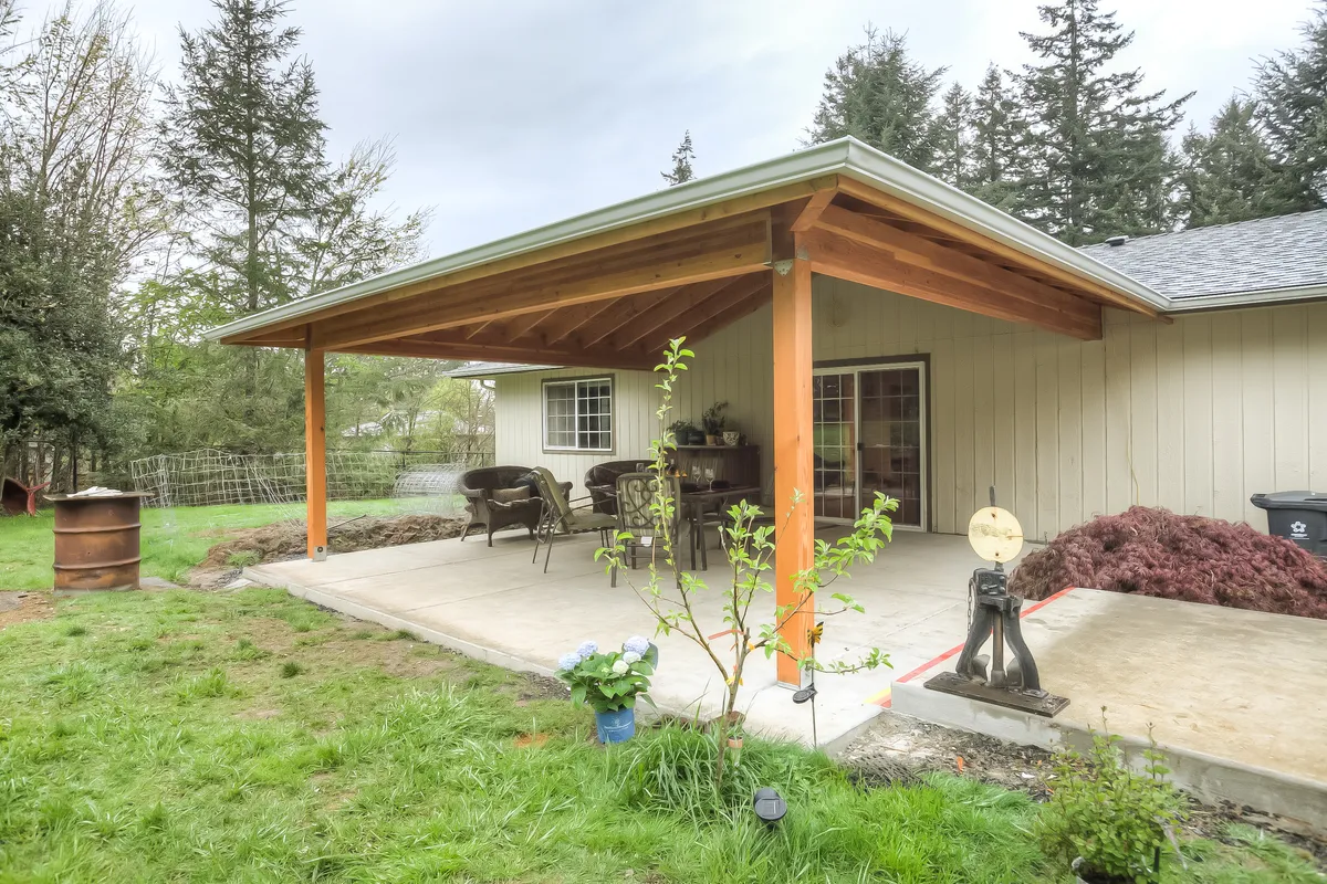 A new covered patio with cedar posts over a concrete slab, behind a single-storey house