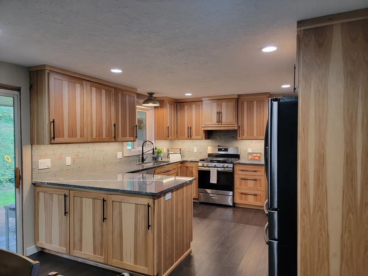 A kitchen with hickory cabinets, a peninsula and stainless appliances