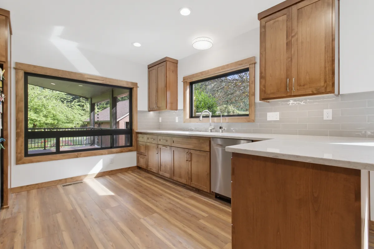 A kitchen with alder cabinets, quartz counters and a big picture window