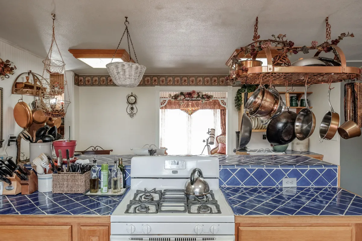 The Lebanon kitchen before: oak cabinets, blue tile counters and a hanging pot rack