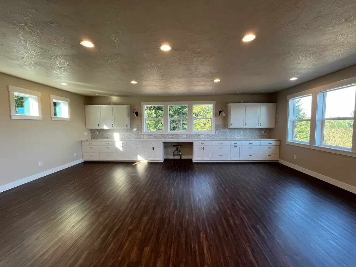 The new craft room: white custom cabinetry, a work desk and new flooring