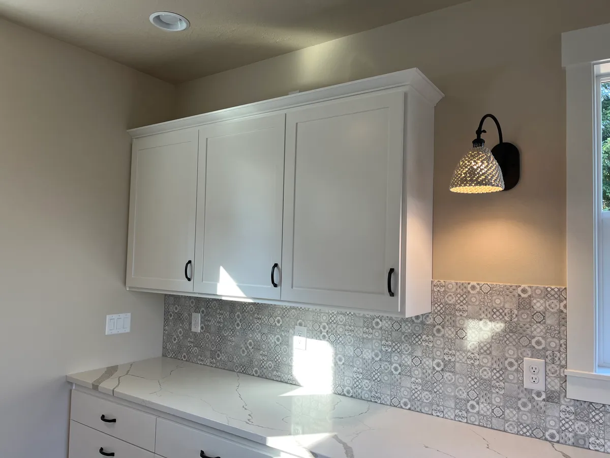 The new craft room: white custom cabinetry, a work desk and new flooring