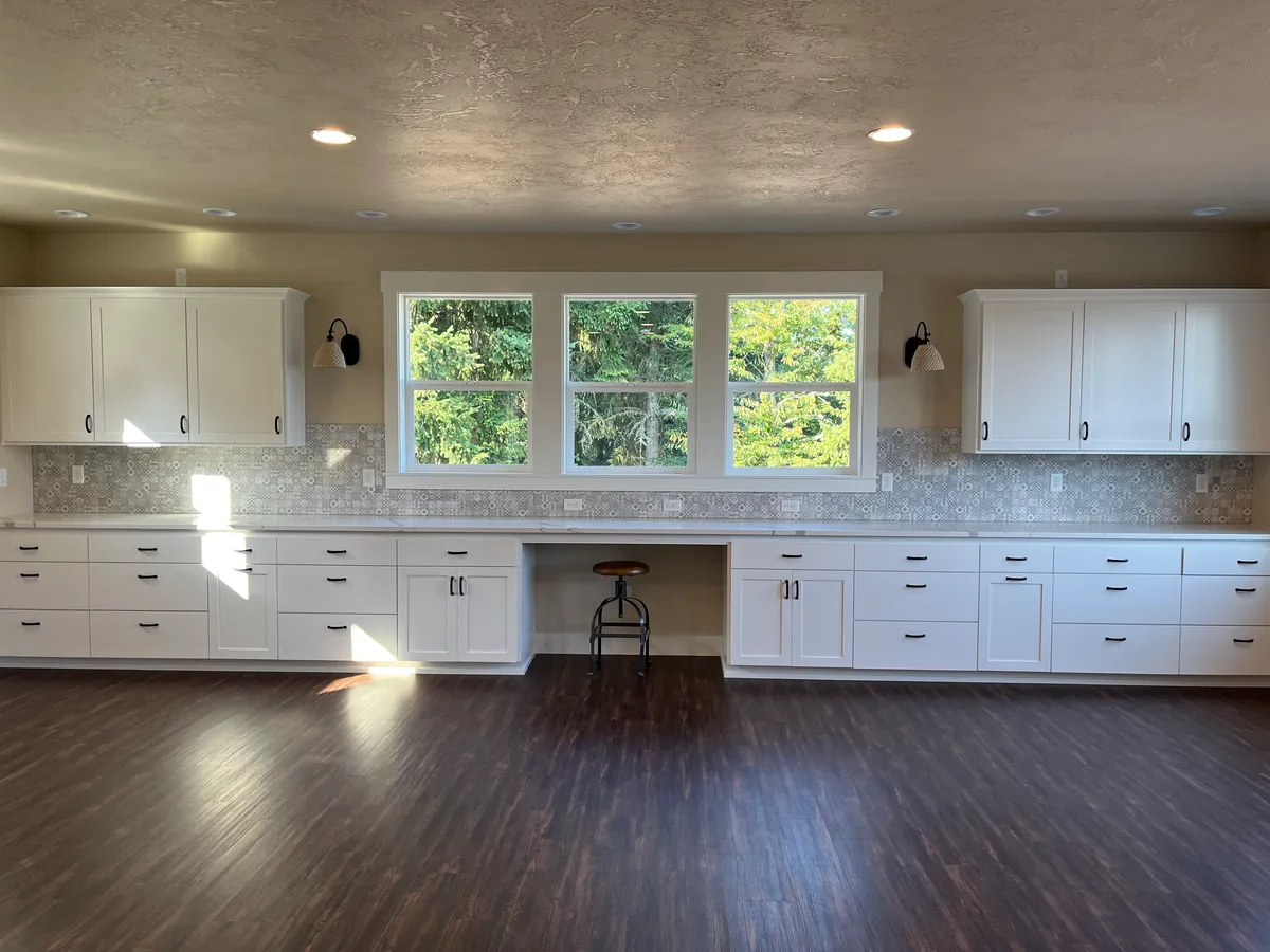 The new craft room: white custom cabinetry, a work desk and new flooring