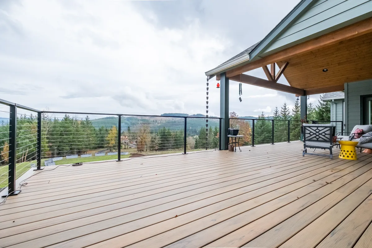 The expanded deck with braided cable railing and valley views