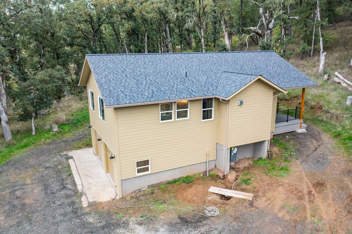 The rebuilt home and two-car garage among the oaks, from above
