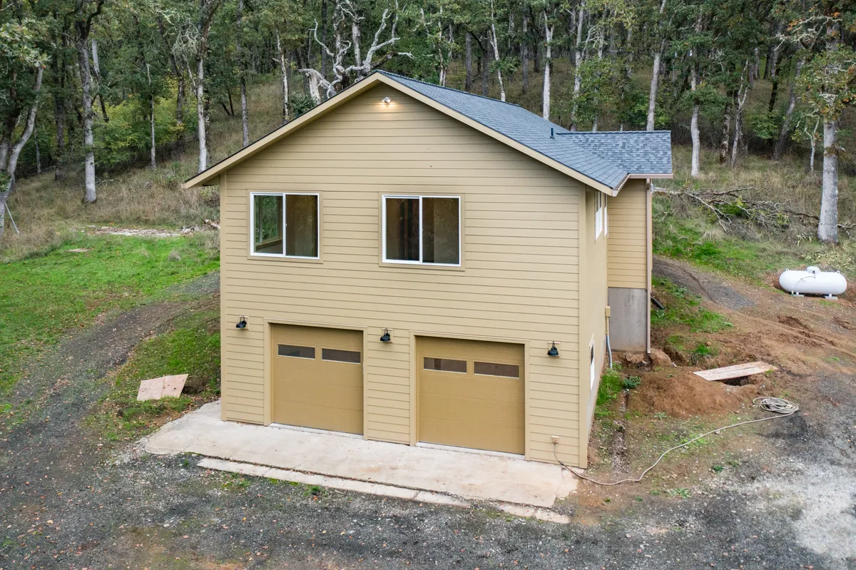 The rebuilt home and two-car garage among the oaks, from above