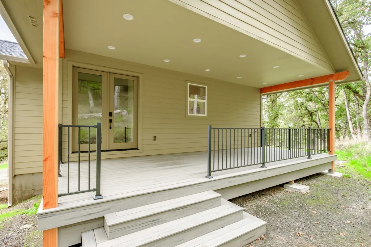 The covered back porch with cedar posts and black railing