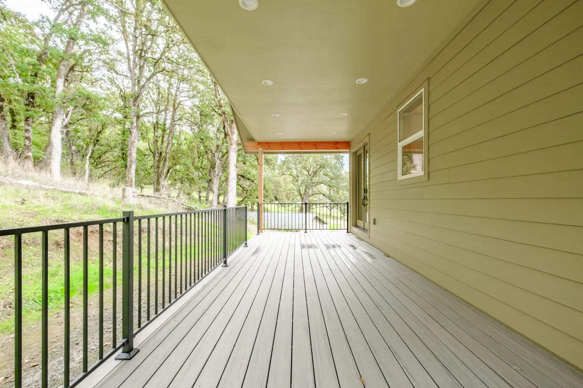 The covered back porch with cedar posts and black railing