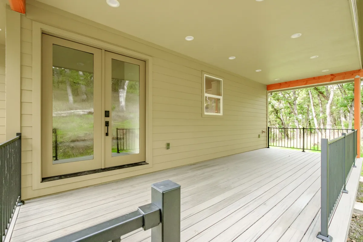 The covered back porch with cedar posts and black railing