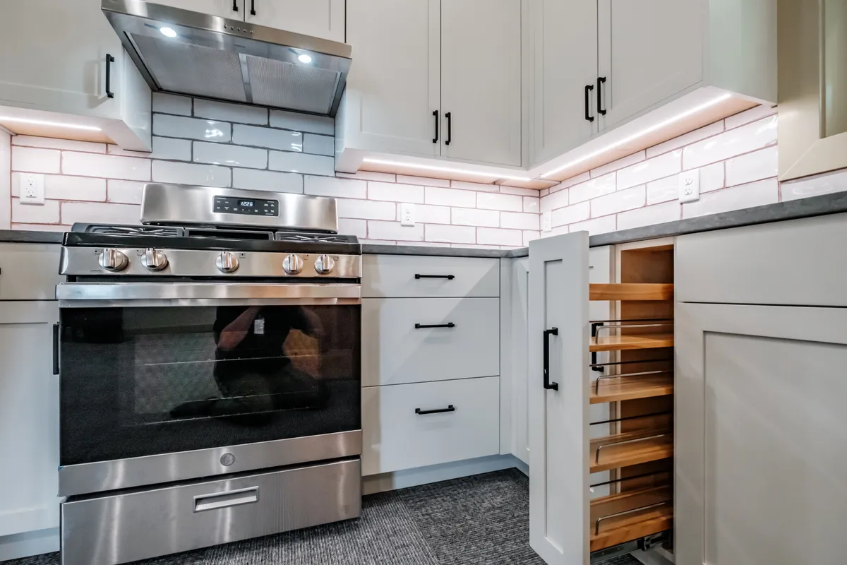 Kitchen with sage cabinets, subway tile and pull-out storage