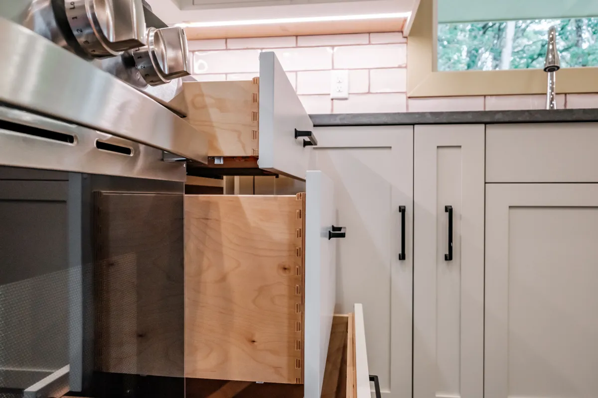 Kitchen with sage cabinets, subway tile and pull-out storage