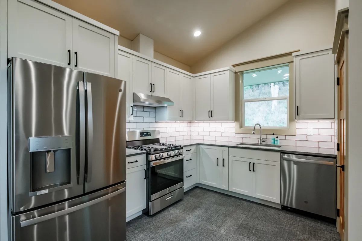 Kitchen with sage cabinets, subway tile and pull-out storage