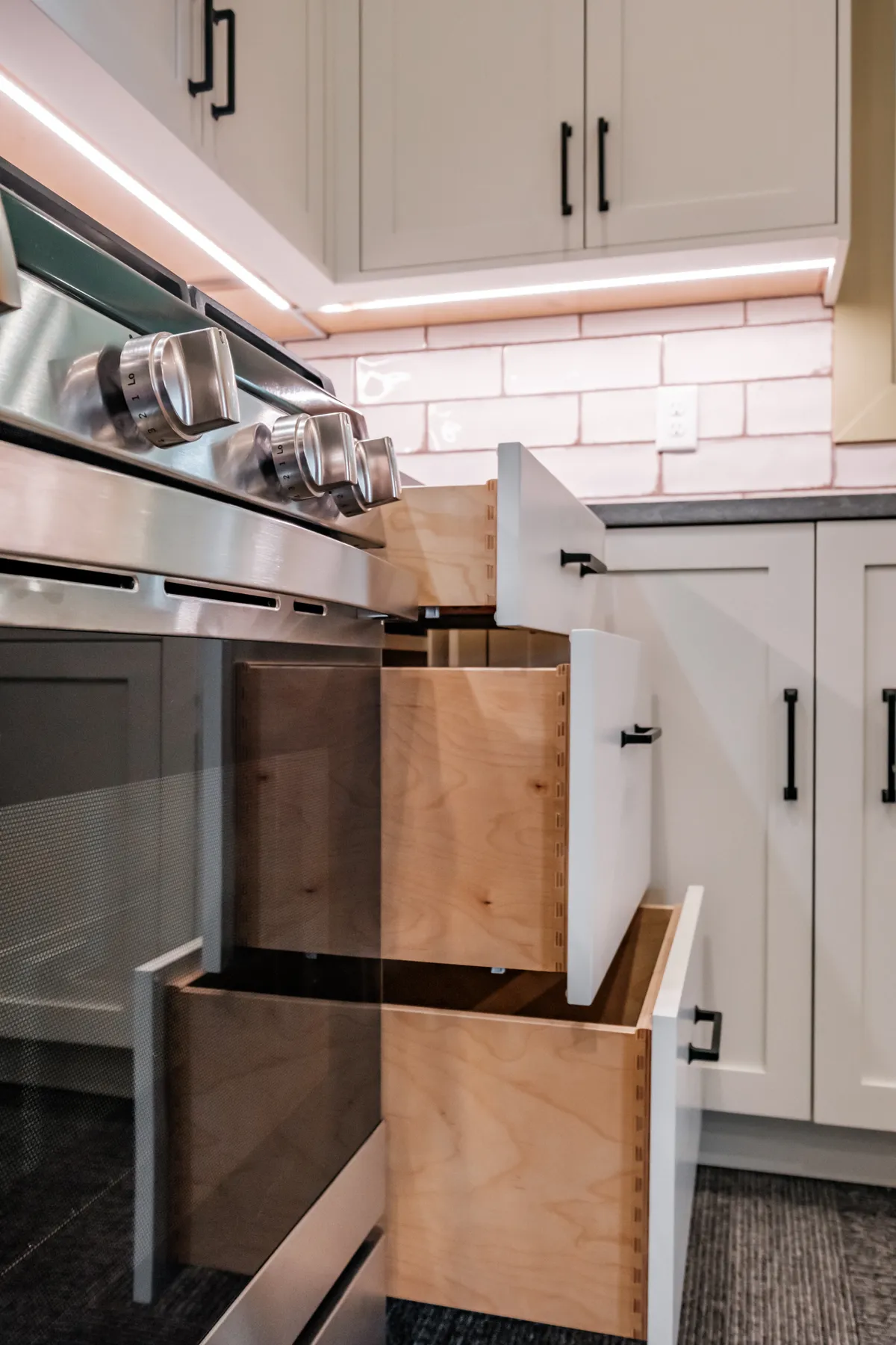 Kitchen with sage cabinets, subway tile and pull-out storage