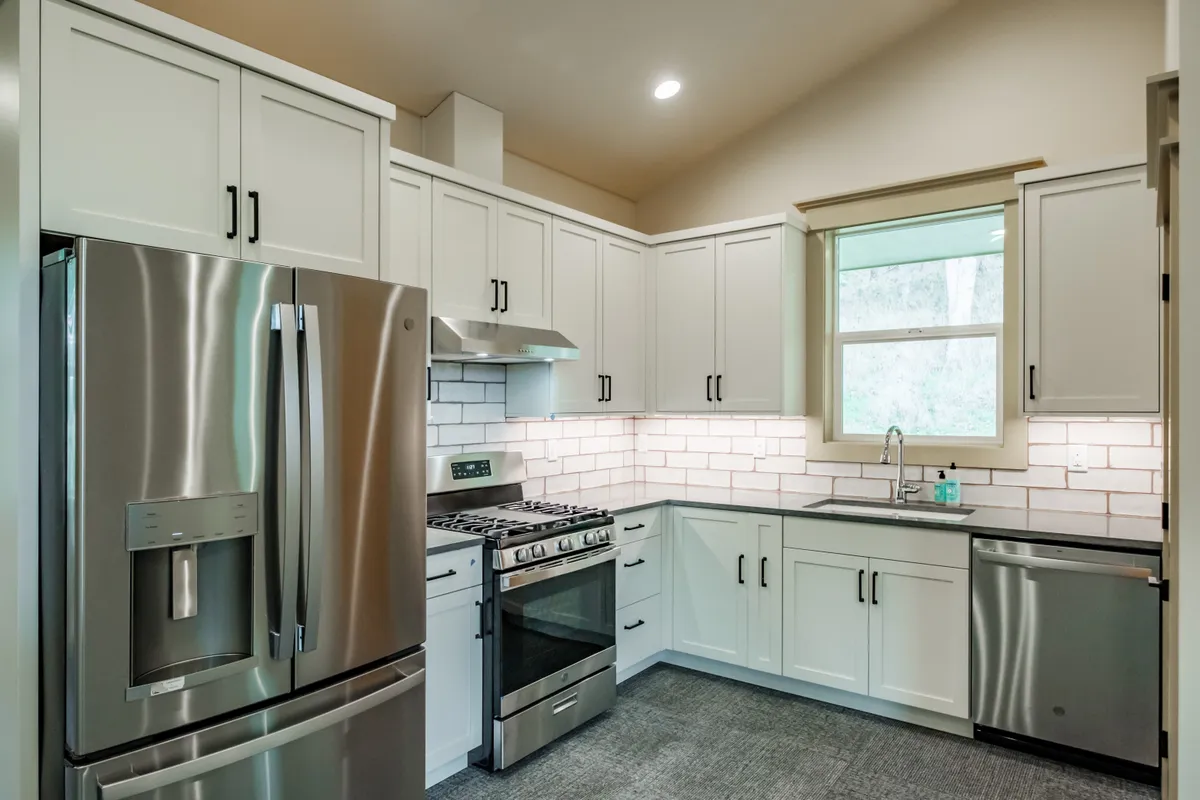 The kitchen: sage cabinets, white subway backsplash and stainless appliances