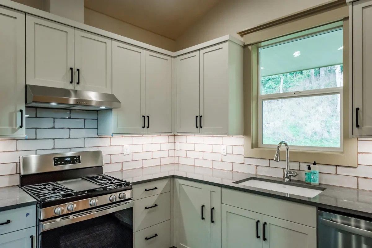 The kitchen: sage cabinets, white subway backsplash and stainless appliances