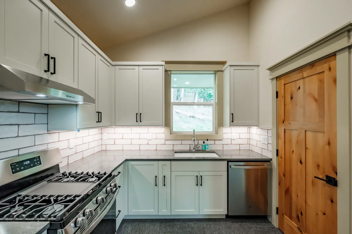 The kitchen: sage cabinets, white subway backsplash and stainless appliances