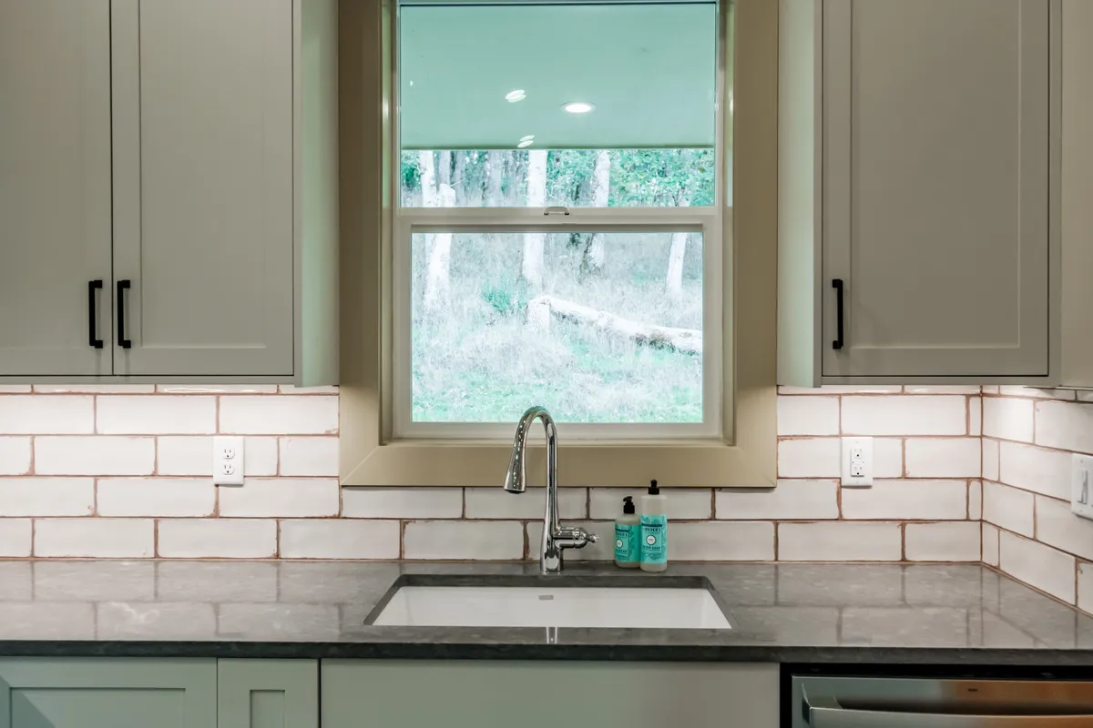 The kitchen: sage cabinets, white subway backsplash and stainless appliances