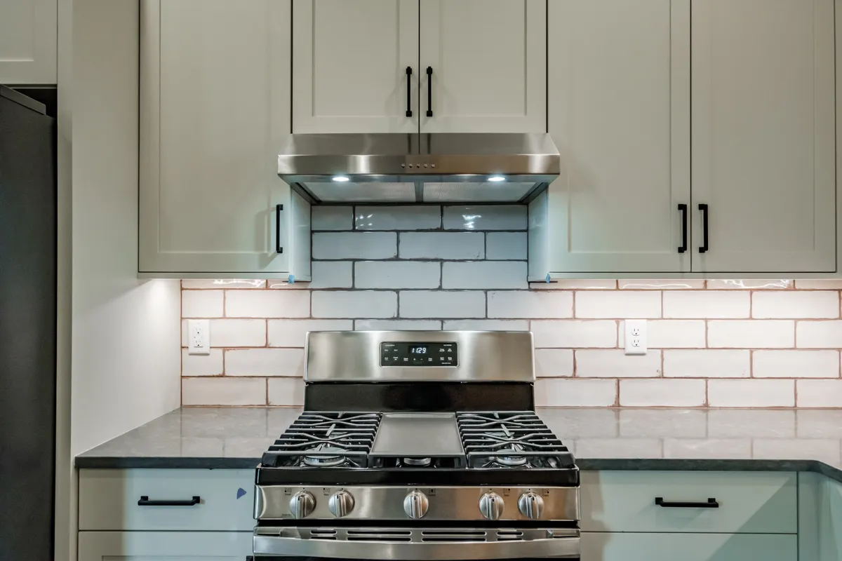 The kitchen: sage cabinets, white subway backsplash and stainless appliances