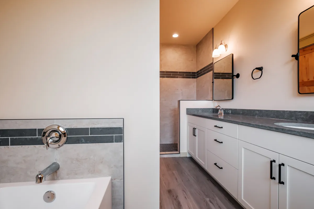 Bathrooms with tiled tub surrounds and dark counters