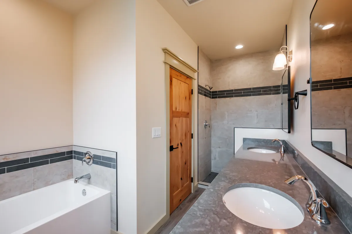 Bathrooms with tiled tub surrounds and dark counters