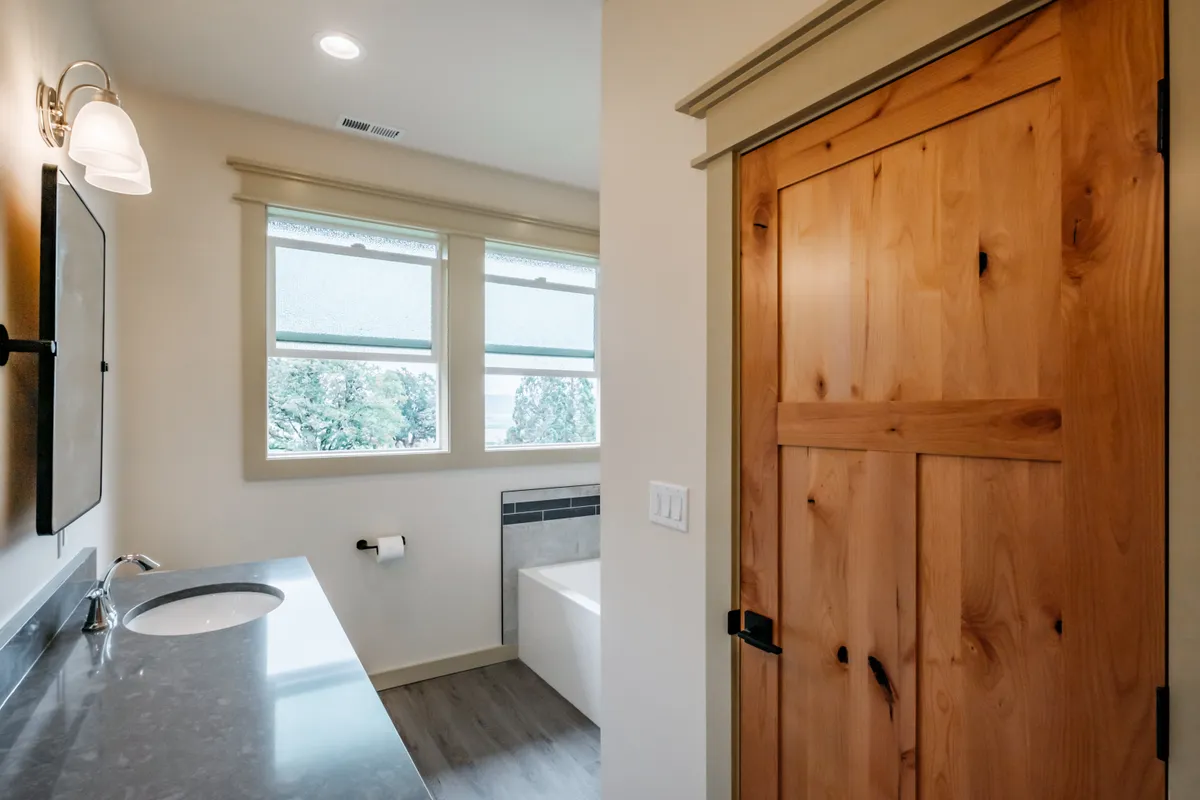 Bathrooms with tiled tub surrounds and dark counters
