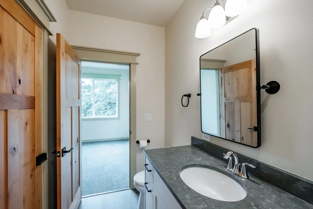 Bathrooms with tiled tub surrounds and dark counters