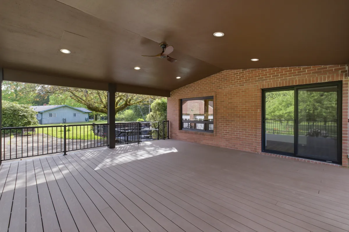 The covered deck with recessed lights and a ceiling fan