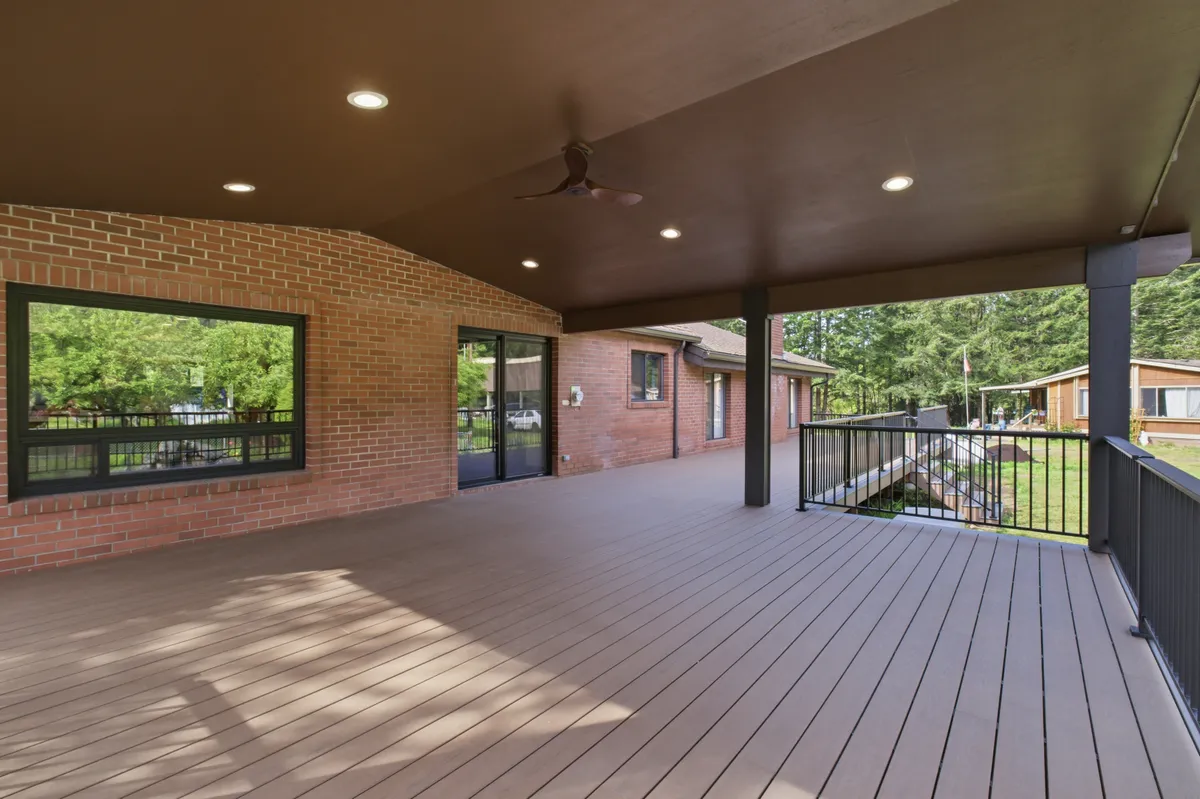 The covered deck with recessed lights and a ceiling fan