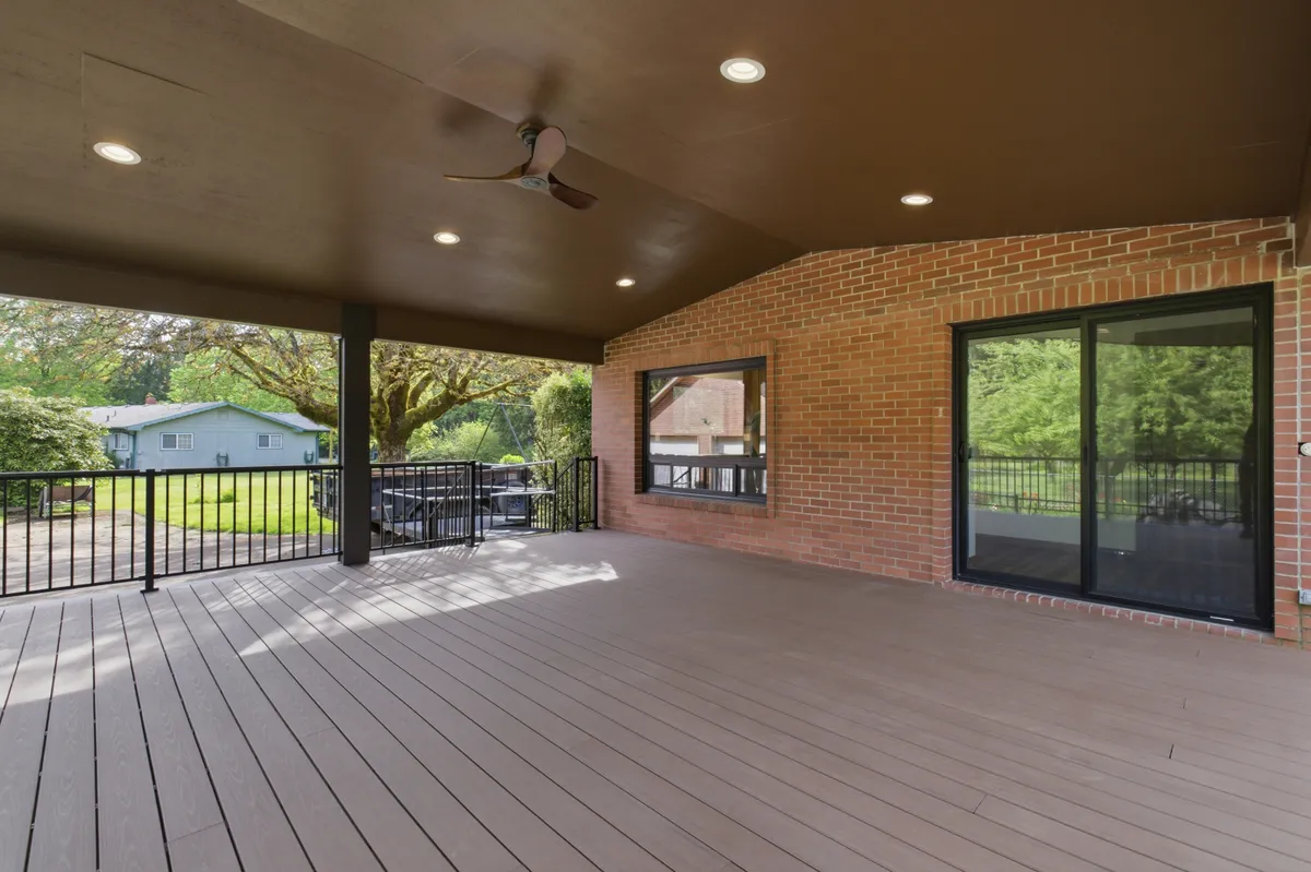 The covered deck with recessed lights and a ceiling fan