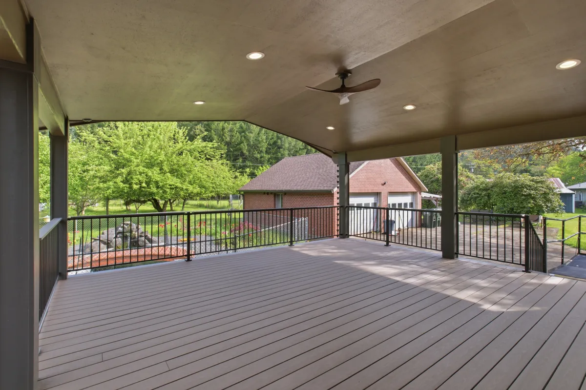 The covered deck with recessed lights and a ceiling fan