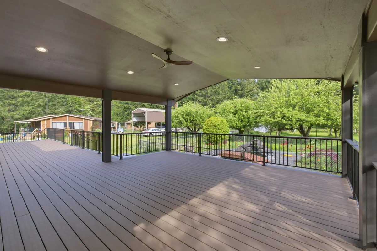 The covered deck with recessed lights and a ceiling fan