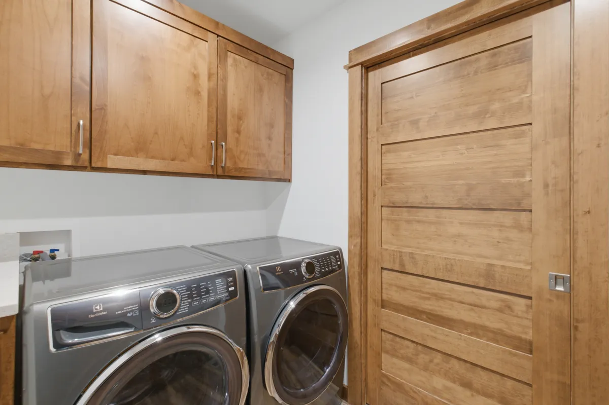 Laundry room with alder cabinets and a front-load washer and dryer