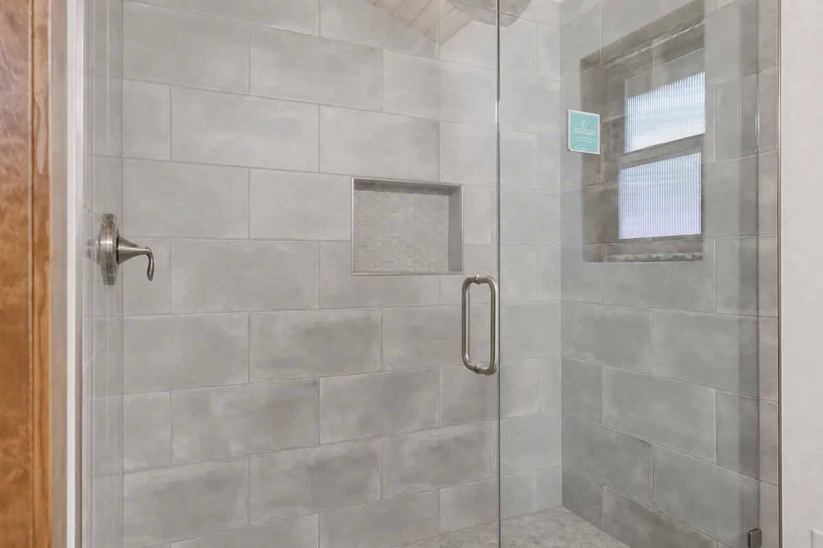 Bathroom vanity and tiled walk-in shower with a glass door