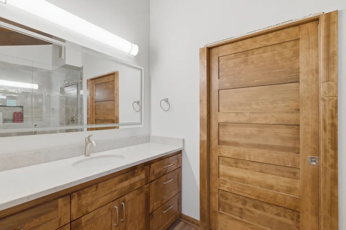 Bathroom vanity with a lighted mirror and an alder door