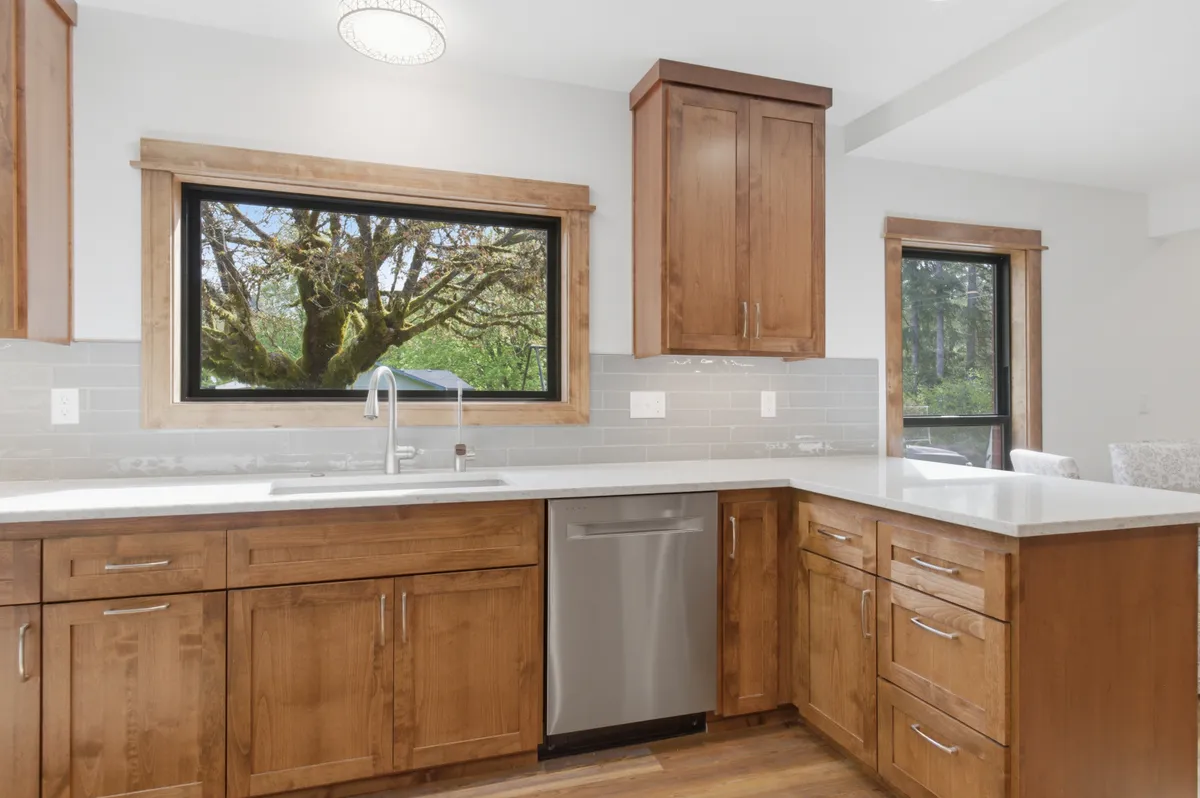 The kitchen: alder cabinets, white quartz counters and a picture window