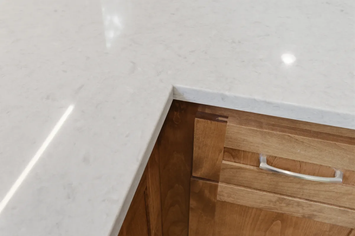 The kitchen: alder cabinets, white quartz counters and a picture window